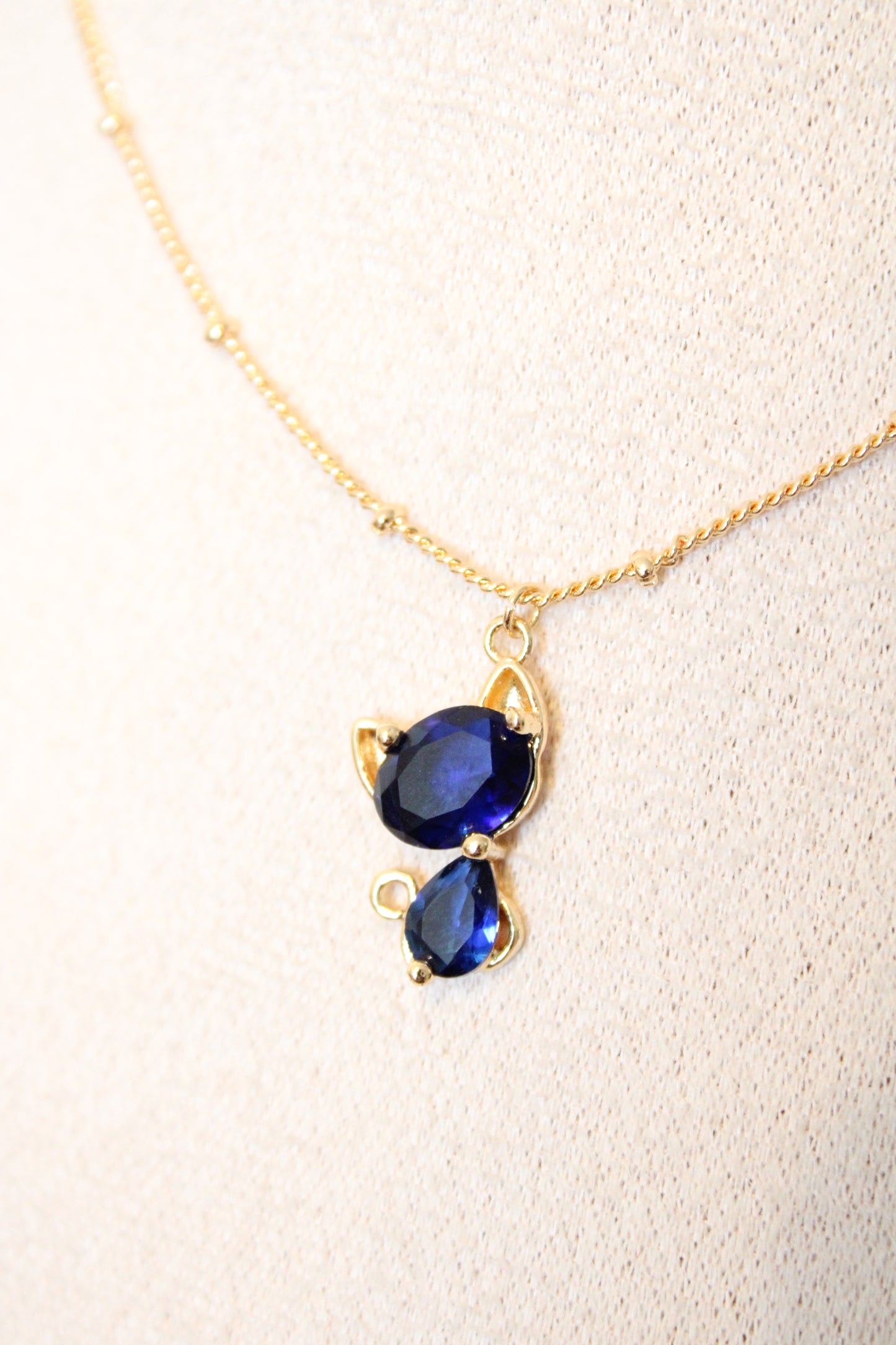 Collier avec pendentif en zircon bleu en forme de chat.