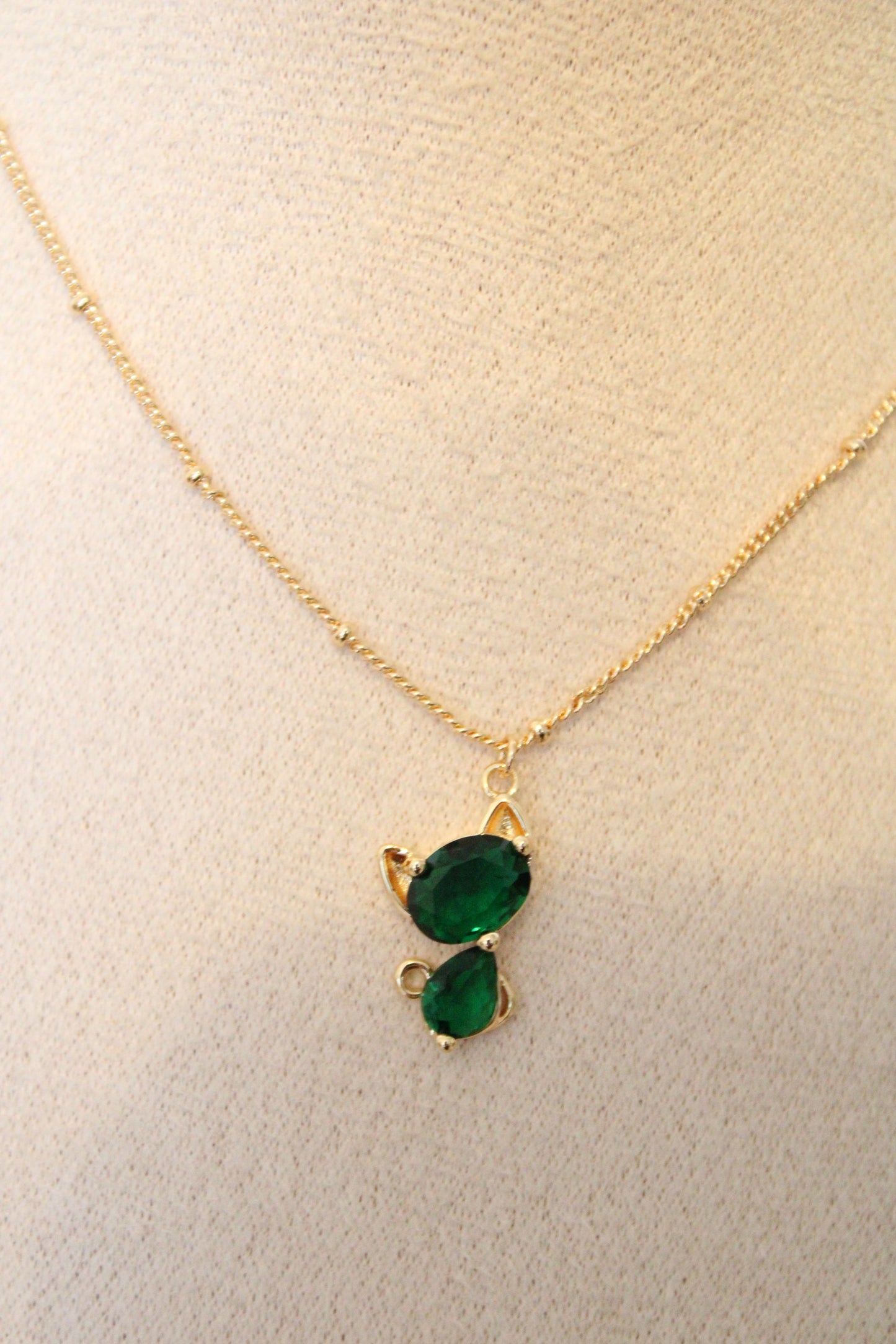 Collier avec pendentif en zircon vert en forme de chat.