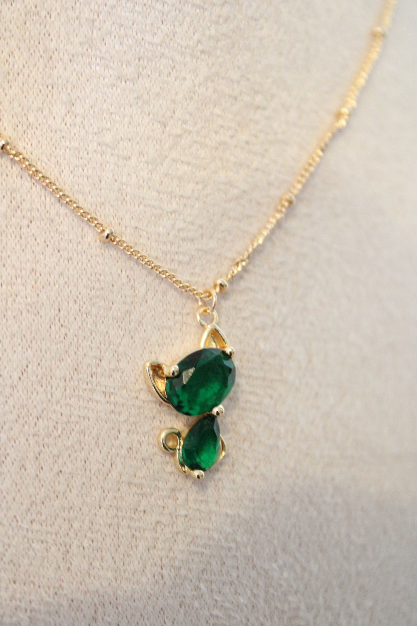 Collier avec pendentif en zircon vert en forme de chat.