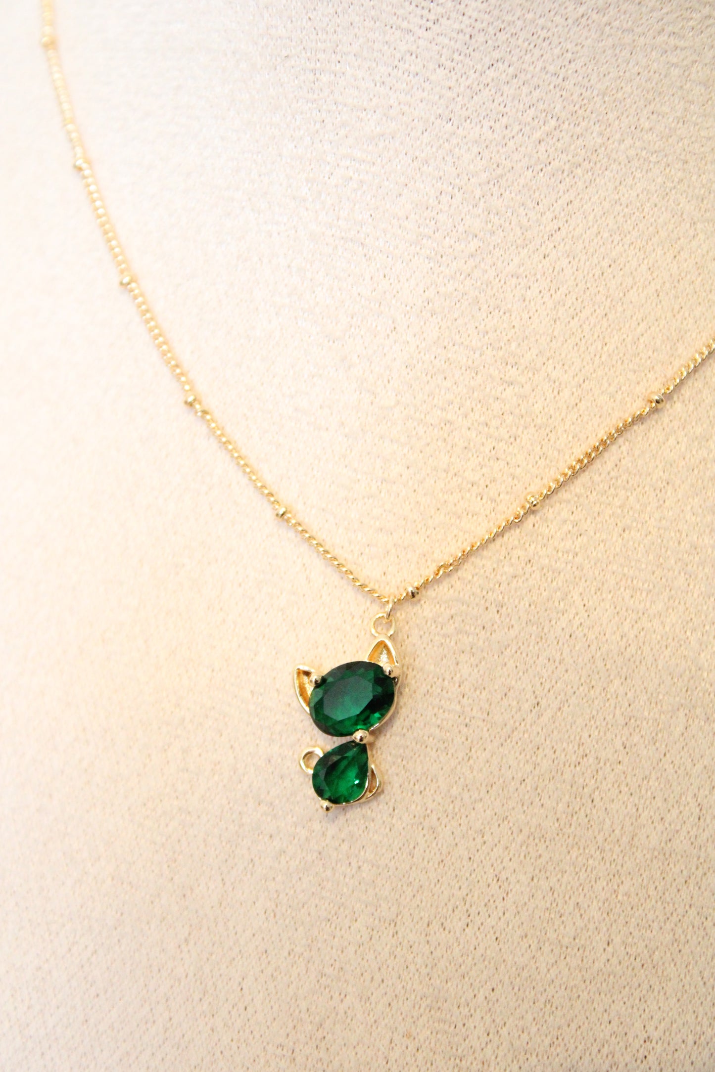 Collier avec pendentif en zircon vert en forme de chat.