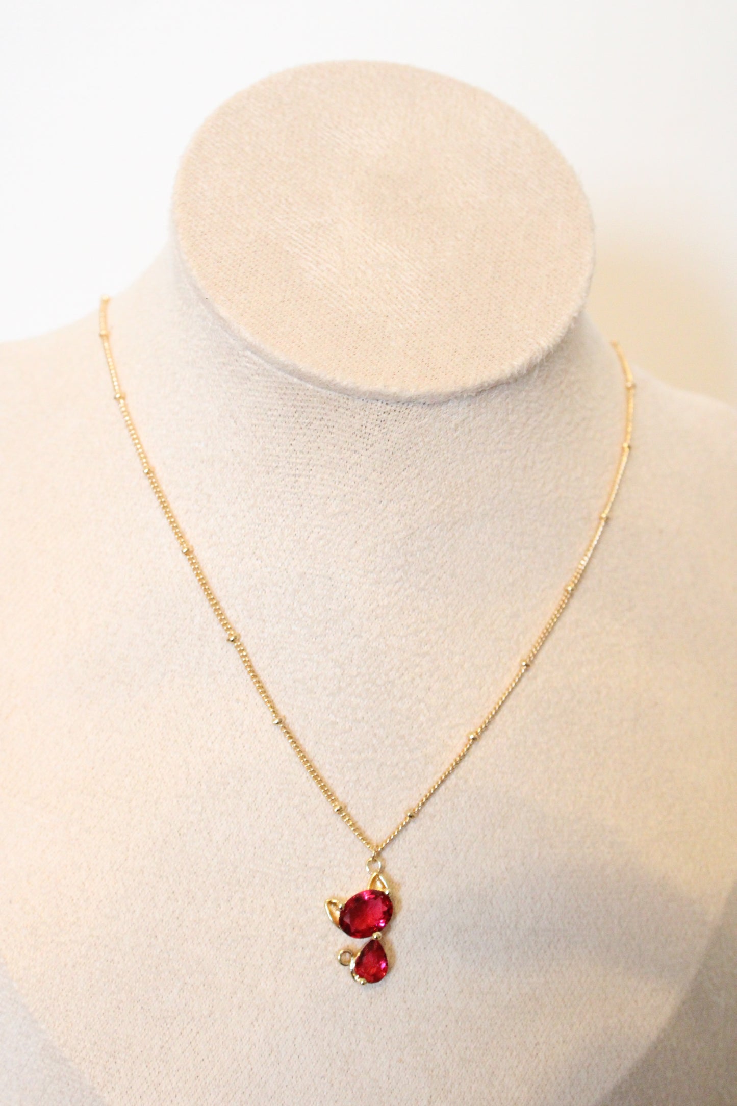 Collier avec pendentif en zircon rouge en forme de chat.