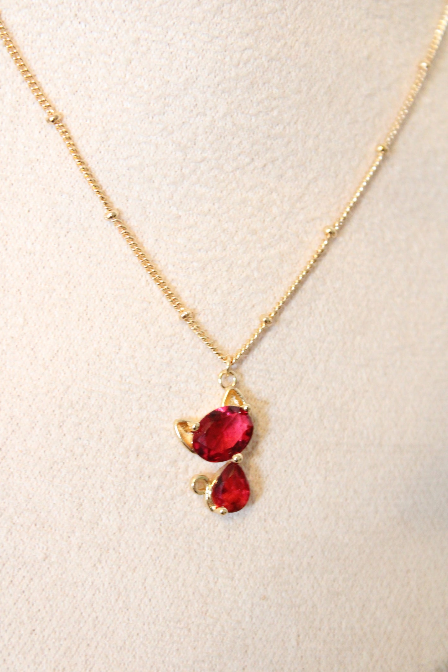 Collier avec pendentif en zircon rouge en forme de chat.